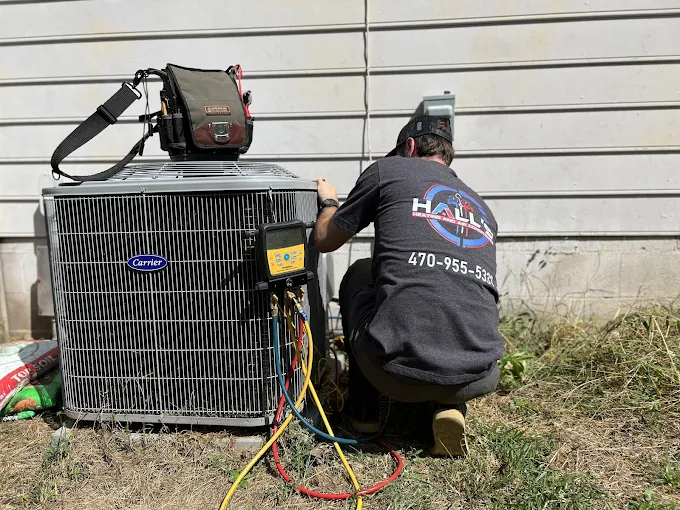 Technician working on air conditioning unit.